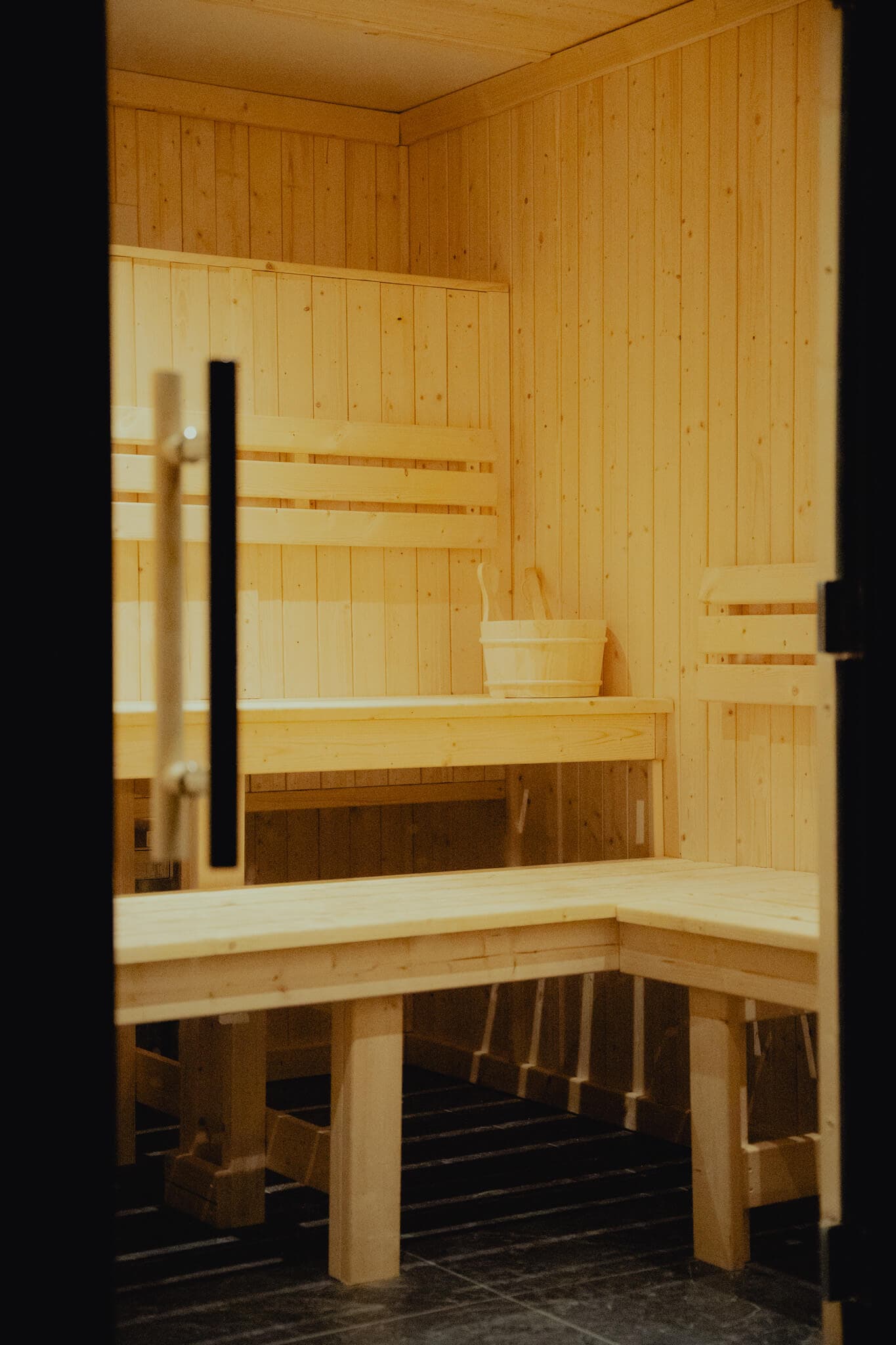 Interior of the sauna suite at Peak Recover, Whaley Bridge, with warm amber lighting